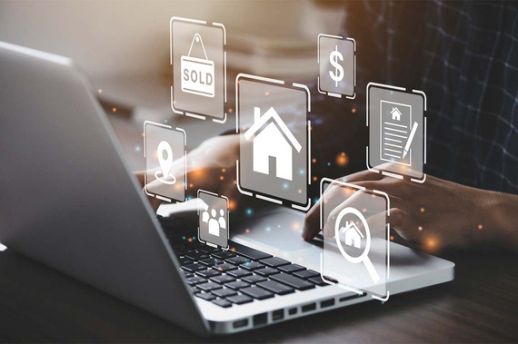 a person using a laptop with real estate icons on the screen